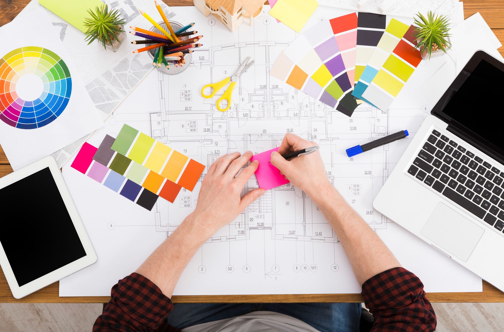 The Basics of Color Theory & How to Apply It In Your Workspace woman writing on a sticky note on her desk with color samples